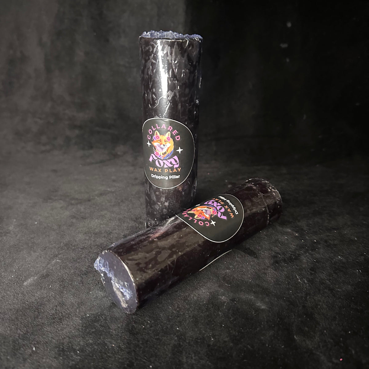 Black paraffin wax play candle on black velvet, An Tine by Collared Foxy
